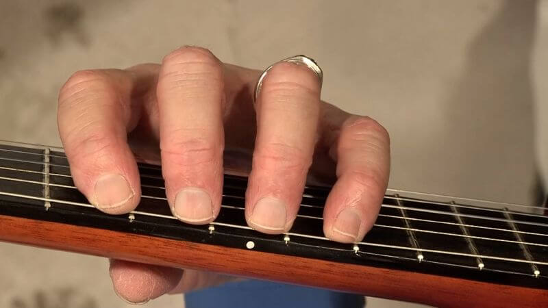 Press the string down to the fret wires